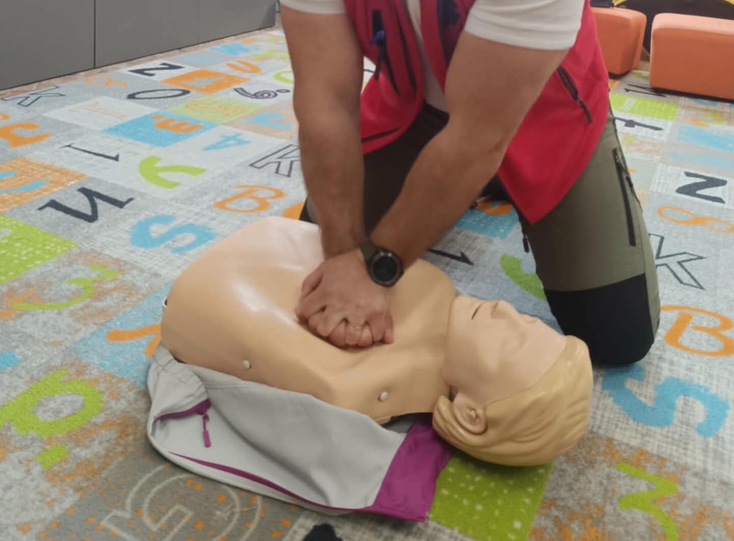 Detail rúk pri stláčaní hrudníka na resuscitačnej figuríne